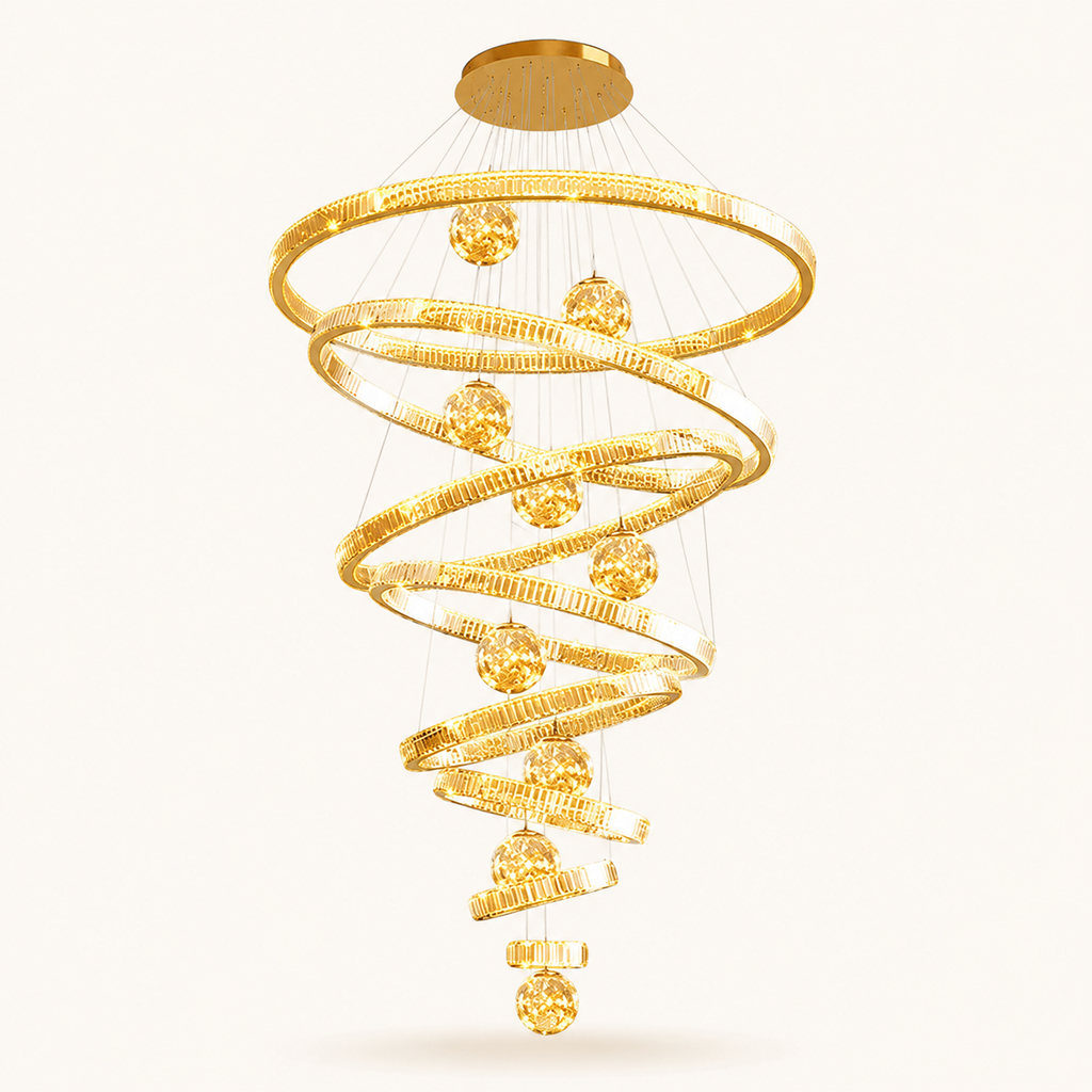 A modern spiral chandelier with textured gold-toned rings and faceted gold crystal-like spheres, suspended from a round ceiling canopy against a plain light background.