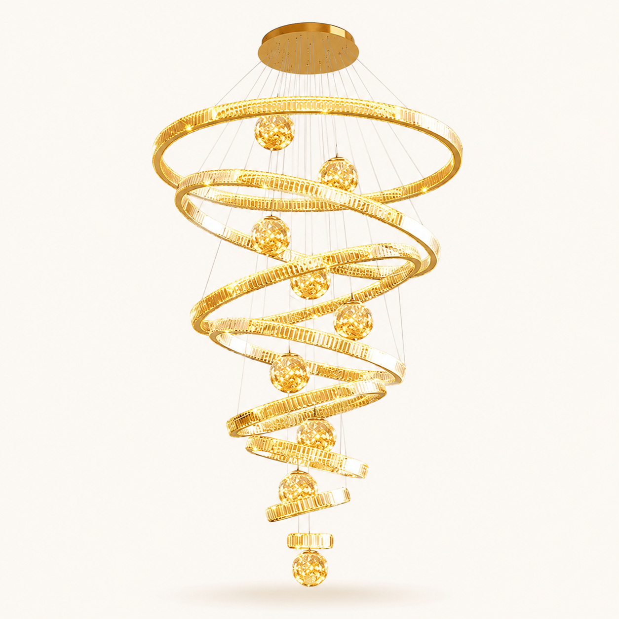 A modern spiral chandelier with textured gold-toned rings and faceted gold crystal-like spheres, suspended from a round ceiling canopy against a plain light background.