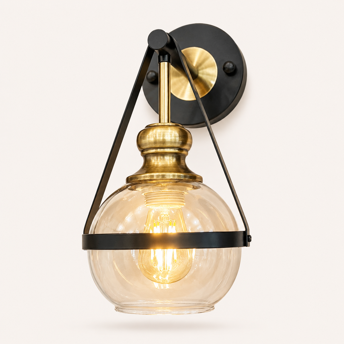 Modern industrial glass wall light with black metal frame, antique brass finish, and clear glass shade for luxury contemporary interiors.