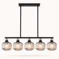 A modern 5-light linear chandelier with ribbed clear glass shades and a matte black metal frame, shown against a plain off-white background.