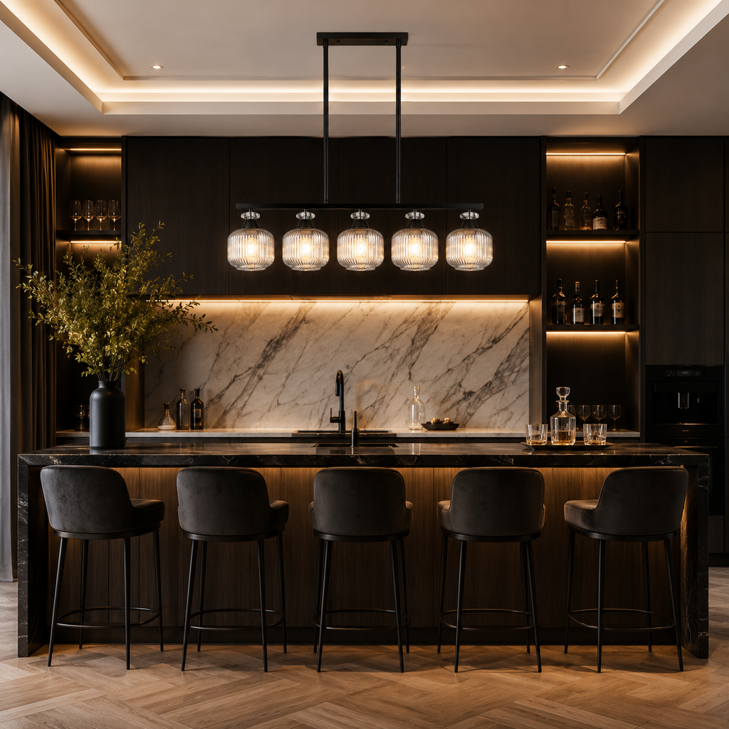 A modern kitchen island with a black marble countertop and backsplash, surrounded by five black bar stools. Above the counter is a black linear pendant light with five clear glass shades.