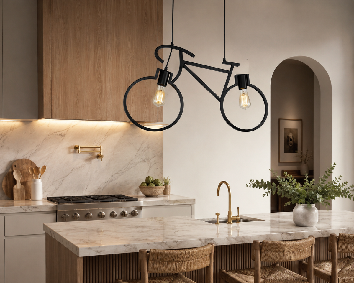 A bicycle-shaped pendant light with two exposed Edison bulbs hangs over a modern kitchen island with a marble countertop and wood cabinetry.