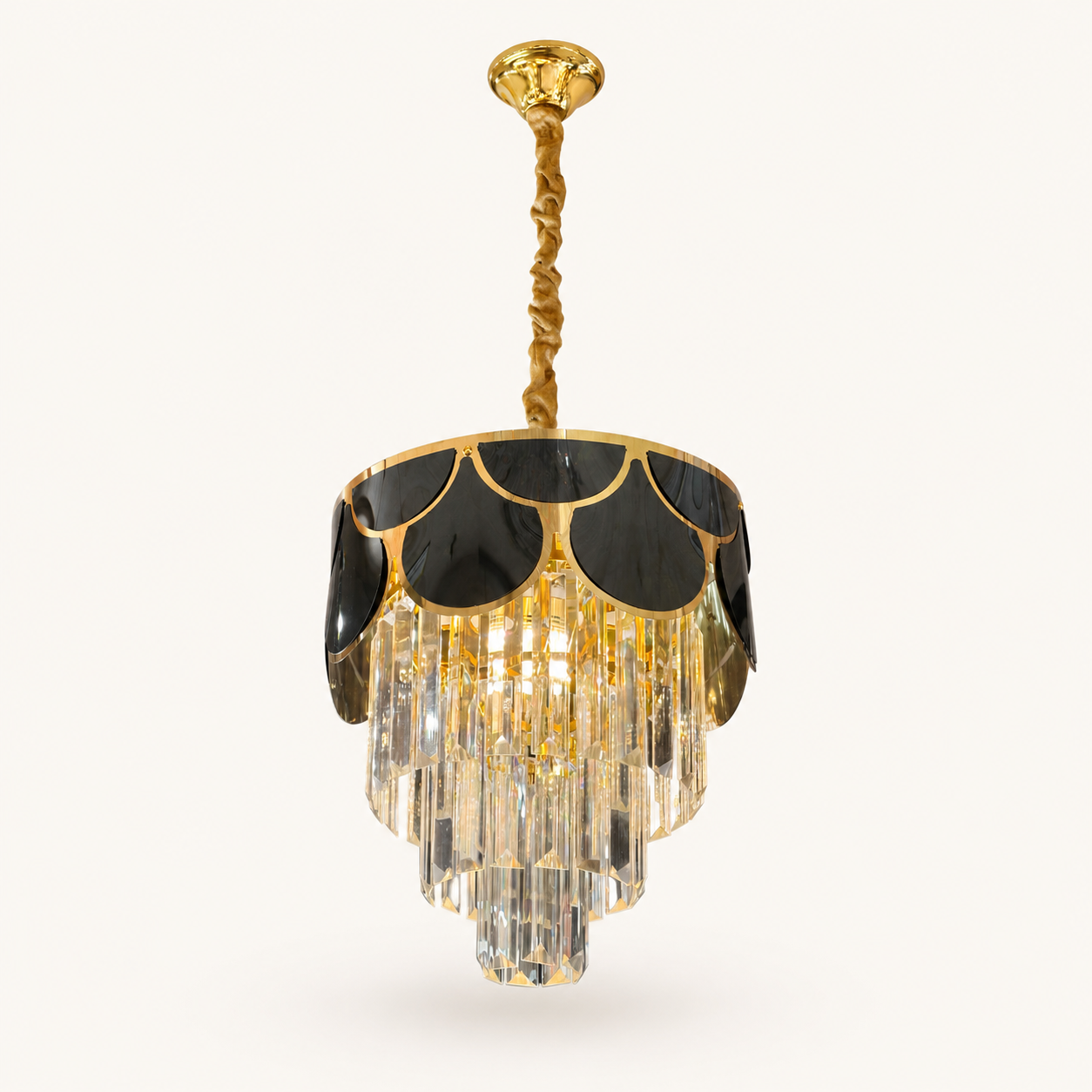 A gold and black chandelier pendant light with clear crystal drops, suspended from a twisted gold rod against a light beige background.