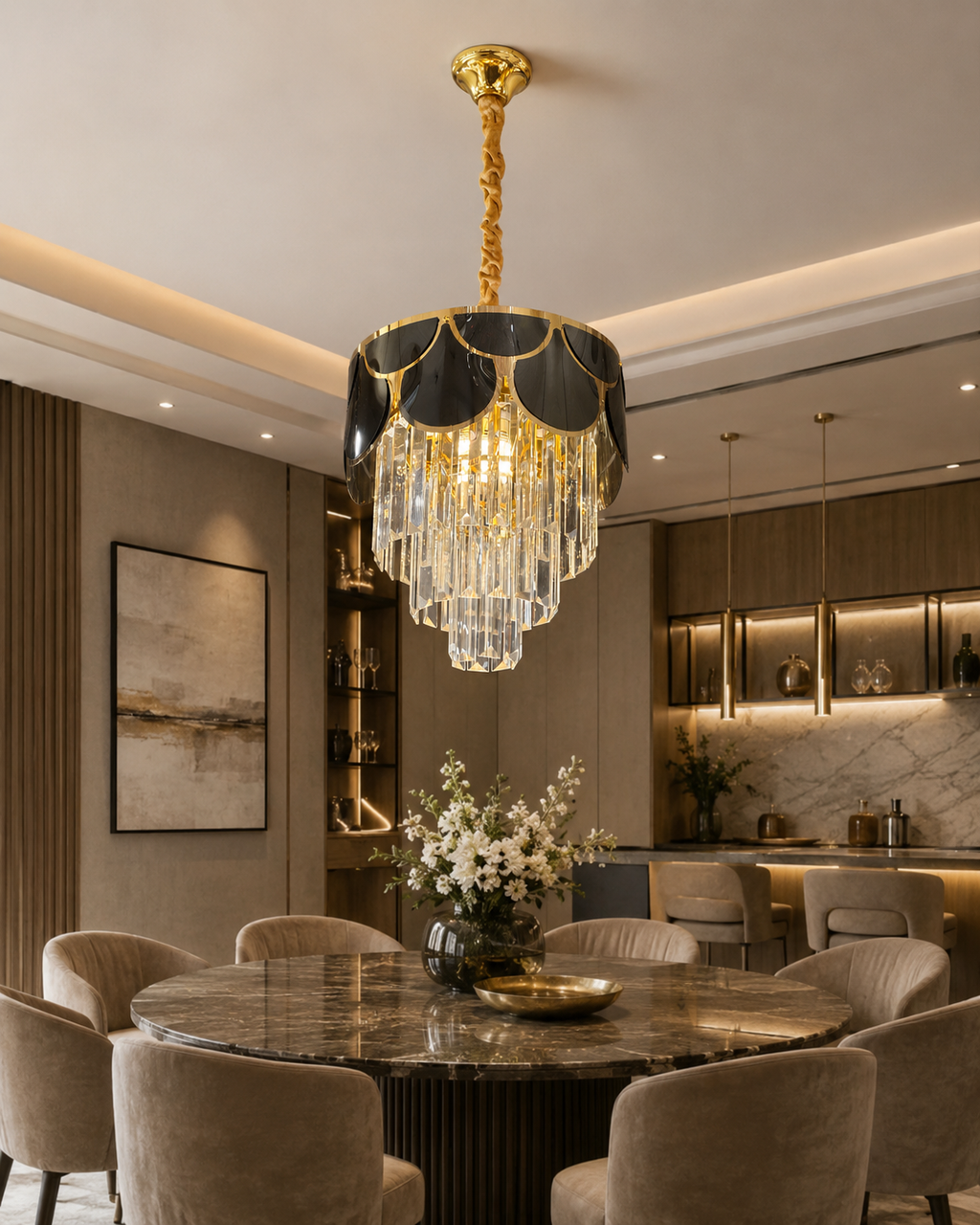 An elegant gold and black chandelier with cascading clear crystal prisms hanging over a round marble dining table in a modern, upscale dining room.